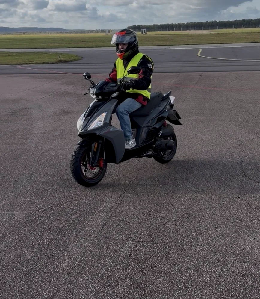 AM-elev på moped under individuell handledning i praktiska körmoment.